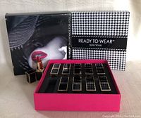 Closed box packaging of lipsticks with Ready To Wear New York label and image of lips with bright lipstick.