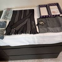 Two men's scarves and two pairs of socks displayed on white surface. Left side shows packaged EdyCalze socks, middle and right display two scarves: one black and gray striped, the other gray in box.