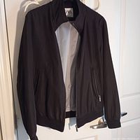 Front view of men's black polyester jacket by Zara with zippered pockets and stand collar.