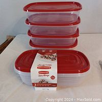 Six Rubbermaid TakeAlongs rectangular plastic containers stacked with lids visible, red lids and translucent white containers.