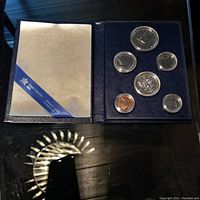 Blue velour tray holds six Canadian coins from 1981 displayed in a protective book-style case with certificate or info on left side and coins arranged on right side.