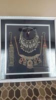 Full view of the framed Bedouin jewelry set including necklace, earrings, ring, and bracelet mounted on black fabric background.