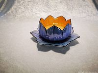 Photo of blue Noritake tulip-shaped dish with orange interior placed on matching blue flower petal saucer