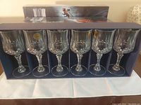 Opened display of six crystal white wine glasses with cut designs, showing clarity and elegance.