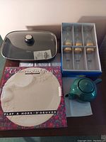 Photo showing Oster electric skillet with glass lid, blue ceramic teapot, Valencia Grove serving platter, and boxed set of four tall glasses