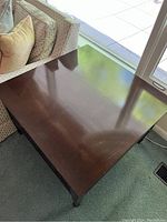Top view of one vintage end table showing smooth dark wood surface and square form.