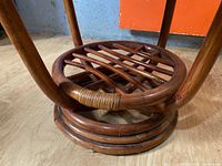 Close-up of table base showing circular wooden construction with crisscross slats and wrapped detailing.