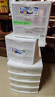 Photo of three stacked white plastic storage bins with 3 drawers each, showing overall size and condition