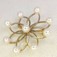 Close-up of the antique pearl brooch showing the floral openwork gold design and the pearls.
