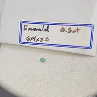 Loose emerald oval gemstone 0.5ct with label showing size 6x4x2.5mm