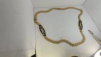 Full view of large vintage gold-tone chain necklace on a white backdrop.