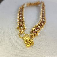 Close-up of the ruby and pearl bracelet showing the clasp and stones.