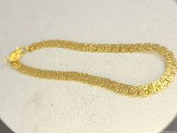 Detailed photo of vintage 5mm wide foldover nugget gold-tone bracelet laid on fabric background, showing chain link texture and clasp.