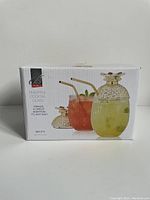 Original box showing the set of 2 pineapple cocktail glasses with straws and lids, branded Brilliant.