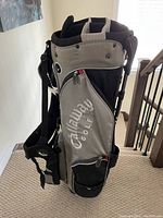 Side view of gray and black Callaway golf bag with zippered pockets and Callaway logo.