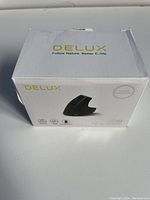 Box front showing Delux brand and product image of the M618DB Ergo Vertical Mouse in black, highlighting ergonomic design.