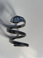 Snake-shaped silver wrist bangle watch showing full coiled design and hexagonal watch face.