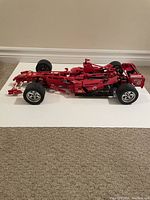 Side view of the red Lego Ferrari Formula 1 car model showing overall length and wheel details.