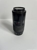 Side view of the Minolta lens showing zoom and focus controls, and part of the lens model info.