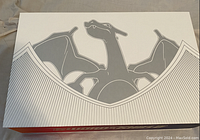 Exterior view of the Pokemon collector's box featuring line art of Charizard in grey on white.