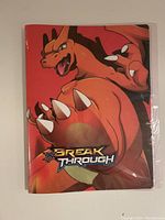 Front cover of the Pokémon card binder featuring Charizard and Break Through logo