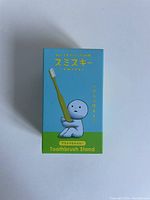 Front view of Smiski toothbrush stand box with green bottom and character holding a toothbrush.