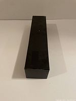 Black rectangular box packaging for the umbrella, viewed from the top.