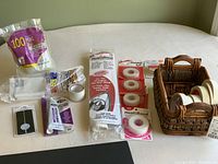 Craft supplies on table, showing basket with tapes and rolls, glue sticks, adhesive tubes and velcro strips
