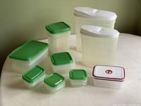 All ten plastic kitchen storage containers arranged in a group, various sizes and lid colors, showcasing the entire set.
