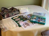 Overall view of craft supply bag and contents on table including fabric pieces, floss organizers and floss bobbins.