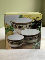 Box showing three nested mixing bowls with intricate floral pattern in cream, yellow, green, and dark blue.