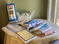 Full view of box contents with batting, fabrics, and rulers on table