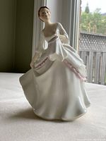 Front angled photo of the Royal Doulton Carol porcelain figurine showing the woman's face, flowing dress, and detailing.