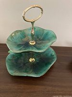 Front angle view showing almost full top and bottom trays, highlighting the green-blue glaze and metal handle