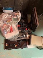 Overview of lot showing Nintendo Wii console wrapped in plastic with game cases, LG DVD player, remote controls, headphones, and several cables.