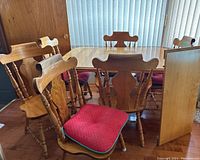 Maple dining table set with 6 chairs and cushioned seats. View captures table dimensions and overall condition.