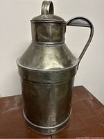 Full side view of the antique pewter creamer pitcher showing body, handle and lid