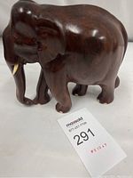 Front and side view of the carved wooden elephant statue on a white background with measurement tape.