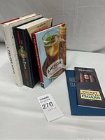 Five books standing upright, showing front and some spines, featuring bar and drinks themes.