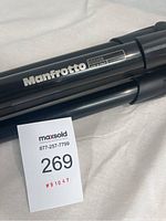 Close-up of Manfrotto logo and model number 055XDB printed on black tripod leg.