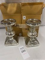 Pair of Pottery Barn antique mercury glass pillar candle holders with original packaging box behind