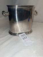 Front view of the silver plated wine chiller showing round handles and polished surface.