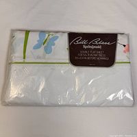 Front of packaged vintage Bill Blass double flat sheet showing brand label and butterfly pattern colors on folded sheet.