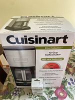 Original box front view displaying Cuisinart Elite Collection 12-Cup Coffeemaker showing product image and main features.
