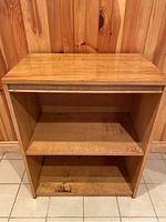 Front view of the solid oak open shelf unit showing two shelves and top surface from the front.