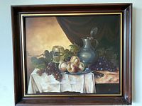 Oil painting depicting still life of grapes, peaches, and a metal pitcher framed in dark wood