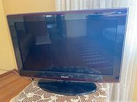 Front view of black Samsung flat screen TV on stand showing screen and bezel.