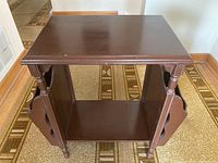 Front view of the vintage wooden magazine rack showing the top surface and side panels with cut-out handle for magazines.