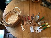 Overview of all items displayed on wood table including baskets, green handled utensils, metal scoop, and assorted bottle and can openers