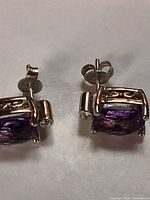 Two earrings laid flat on a light surface